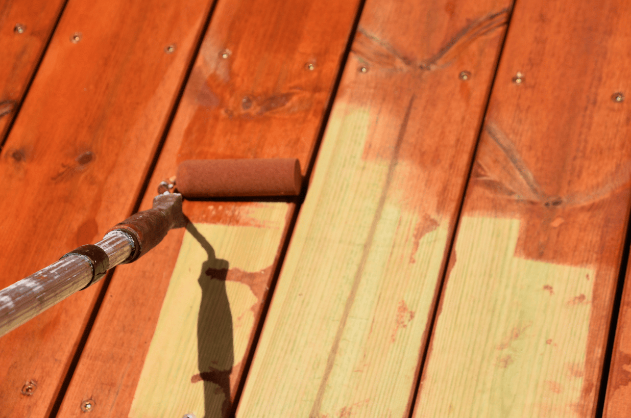 paint roller staining a wood deck after dustless blasting